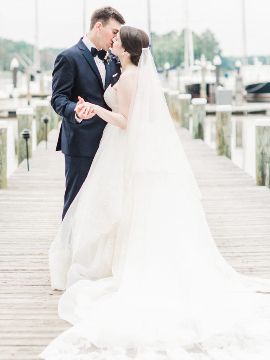 Wedding couple kissing on dock.