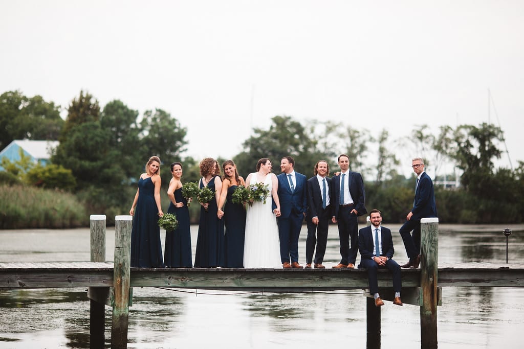 Wedding party posing on dock.