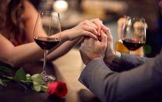 Photo of a Couple Holding Hands at Dinner. Click Here for Valentine’s Day Ideas in Maryland.